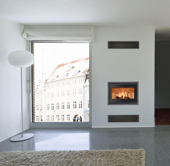 Schwarzer Kamineinsatz mit Flammen Scan 1005 in die Wand eingelassen in einem weißen Wohnzimmer mit großen Fenstern
