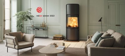 Schwarzer Kamin Scan 87 und Protokoll Red Dot Award Winner 2022 in hellgrünem Interieur mit hellbraunem Sofa und Sessel