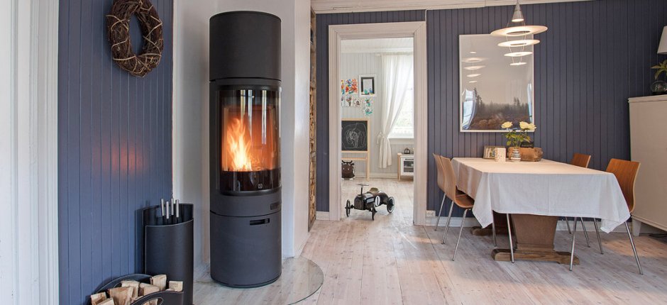 Ein schwarzer kamin steht in der ecke des zimmers und heizt den raum.