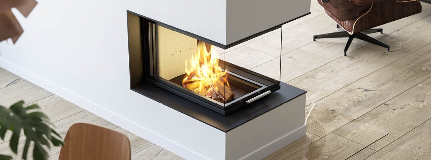 Aufnahme von oben großer Kamineinsatz Scan 5005 FRL mit Glas an drei Seiten und Schiebetür auf rustikalem Holzboden und braunem Ledersessel daneben