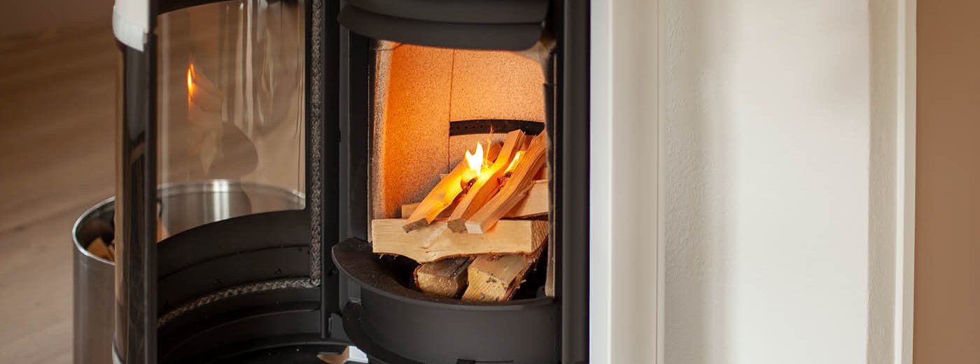 Weißer Kaminofen Scan 83-2 mit offener Tür und angezündetem Feuer