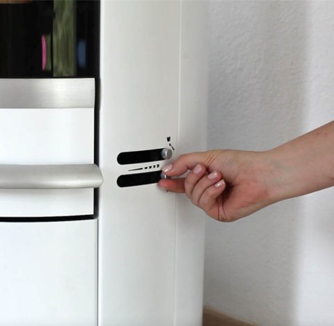 Nahaufnahme der Seite eines weißen Scan 83-2-Holzofens und einer Frauenhand, die die Luftventile einstellt